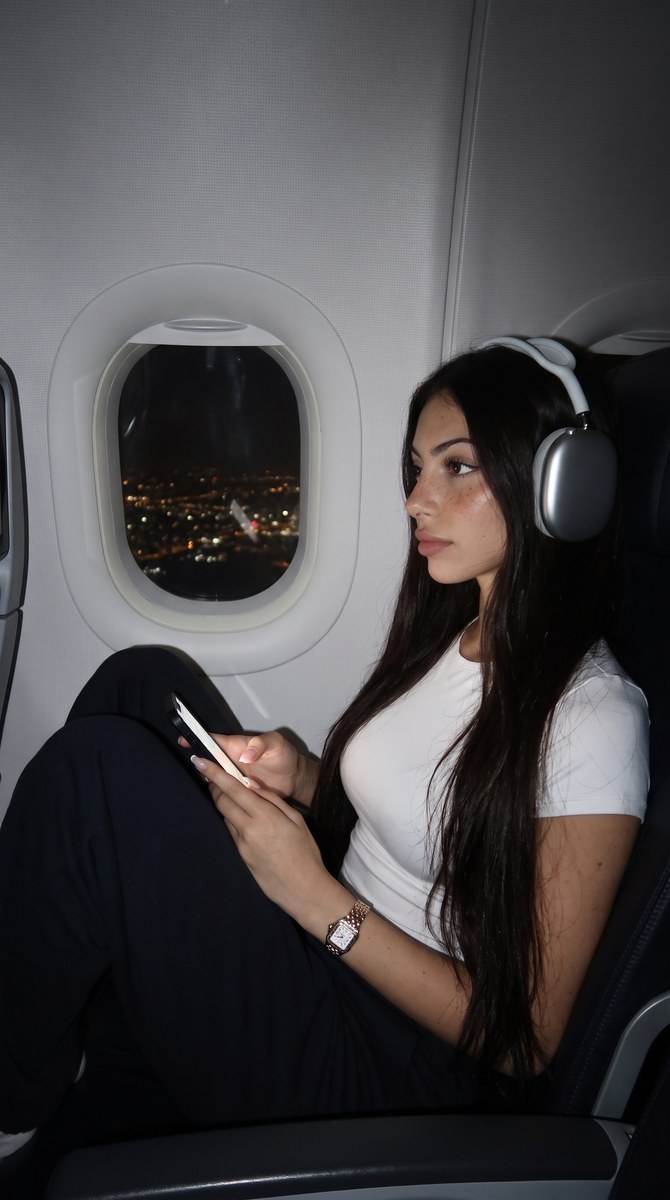 Young Woman by an Airplane Window at Night