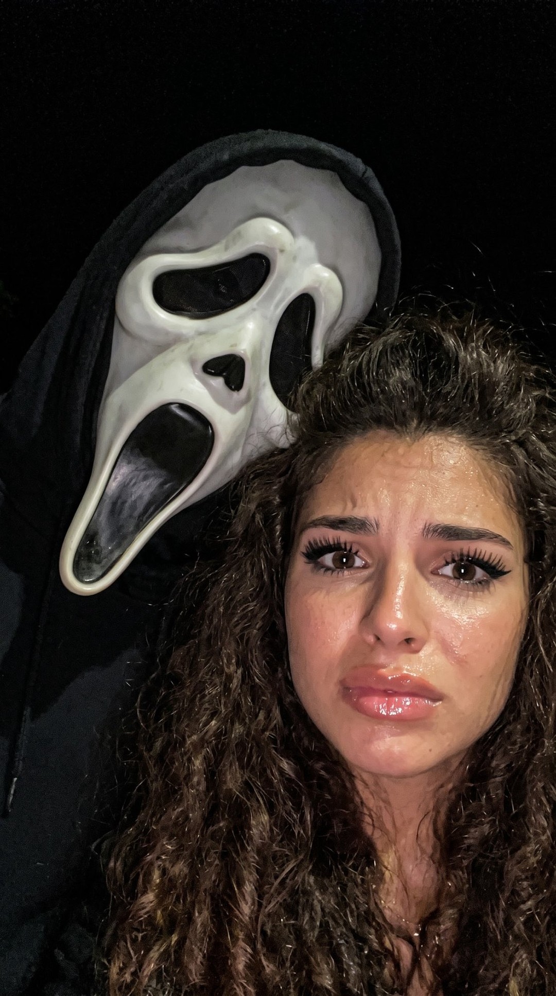 Flash-lit horror selfie with a masked figure