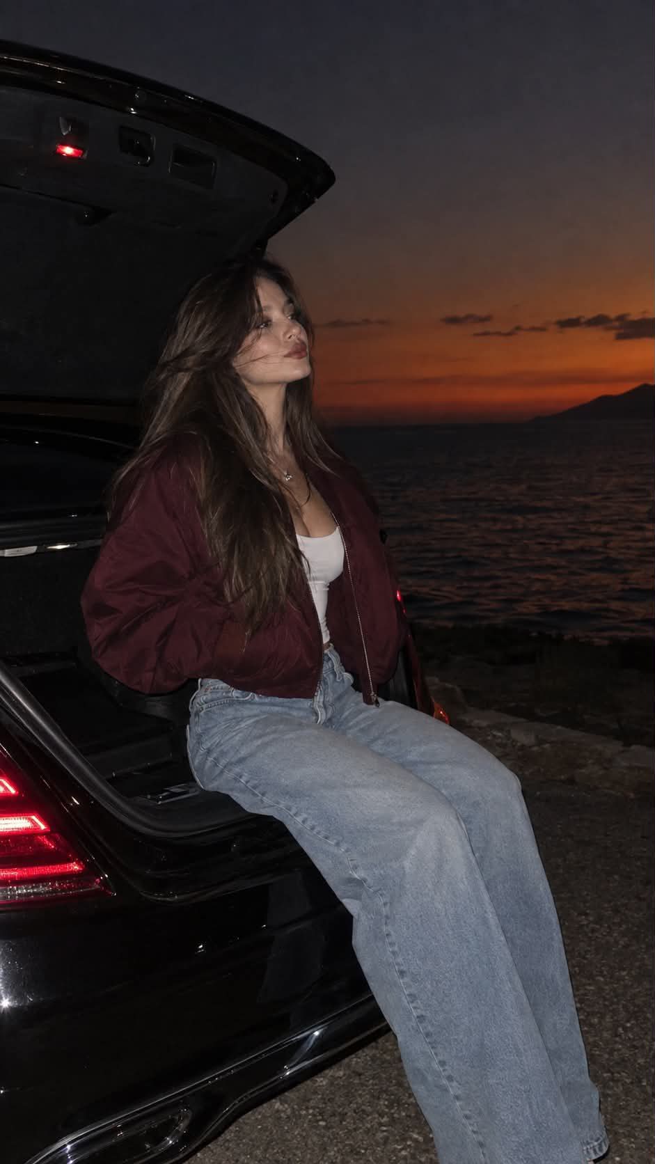 Woman by an Open Mercedes Trunk at Sunset