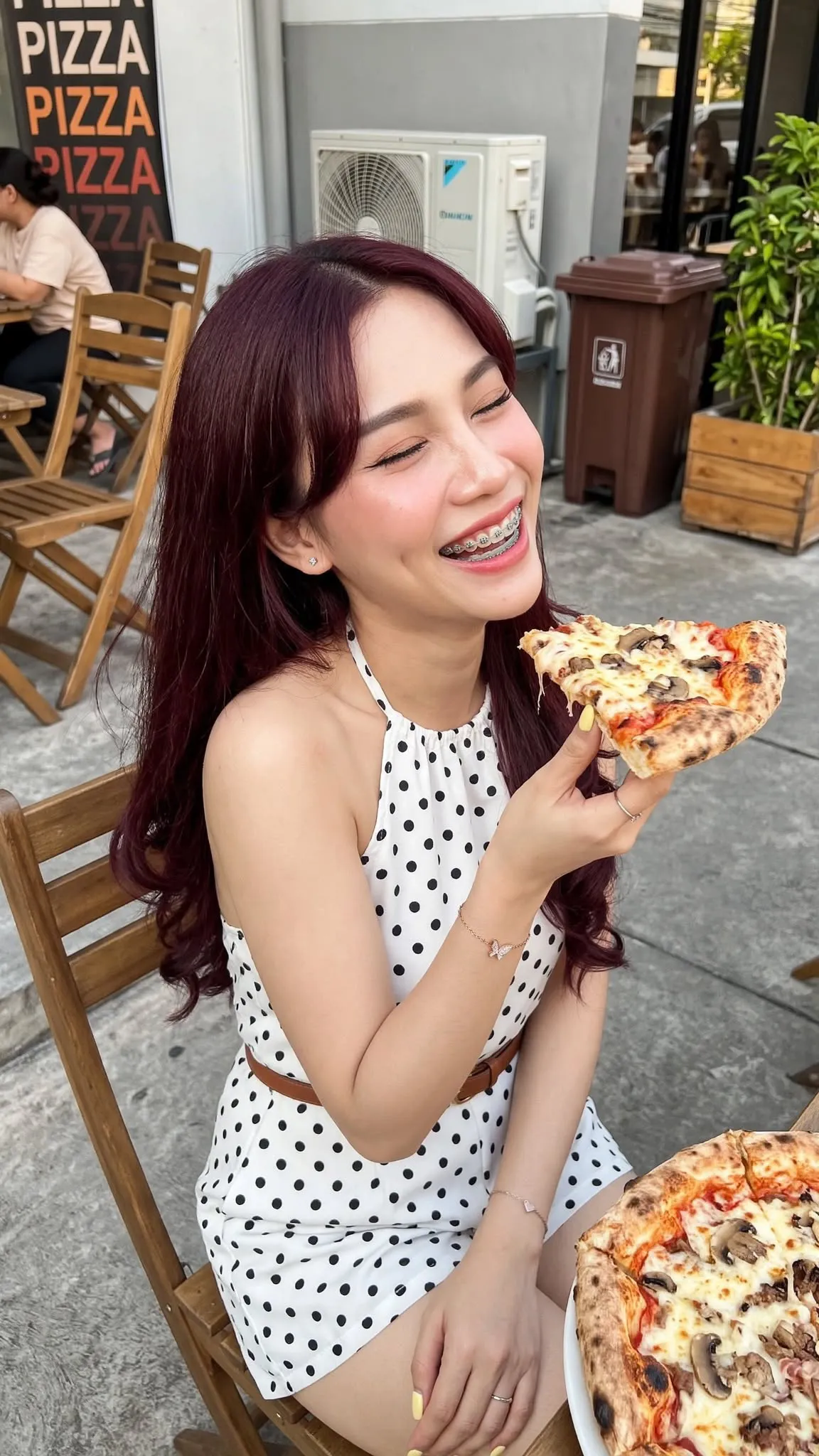 Young Woman Eating Pizza at an Outdoor Restaurant output 3